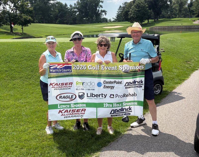 Golfers holding a sponsor banner at the 2026 Warrick County Chamber Golf Scramble